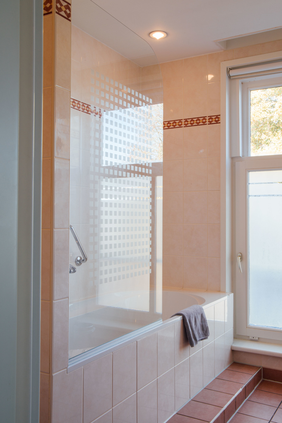 Badkamer met bad en douche